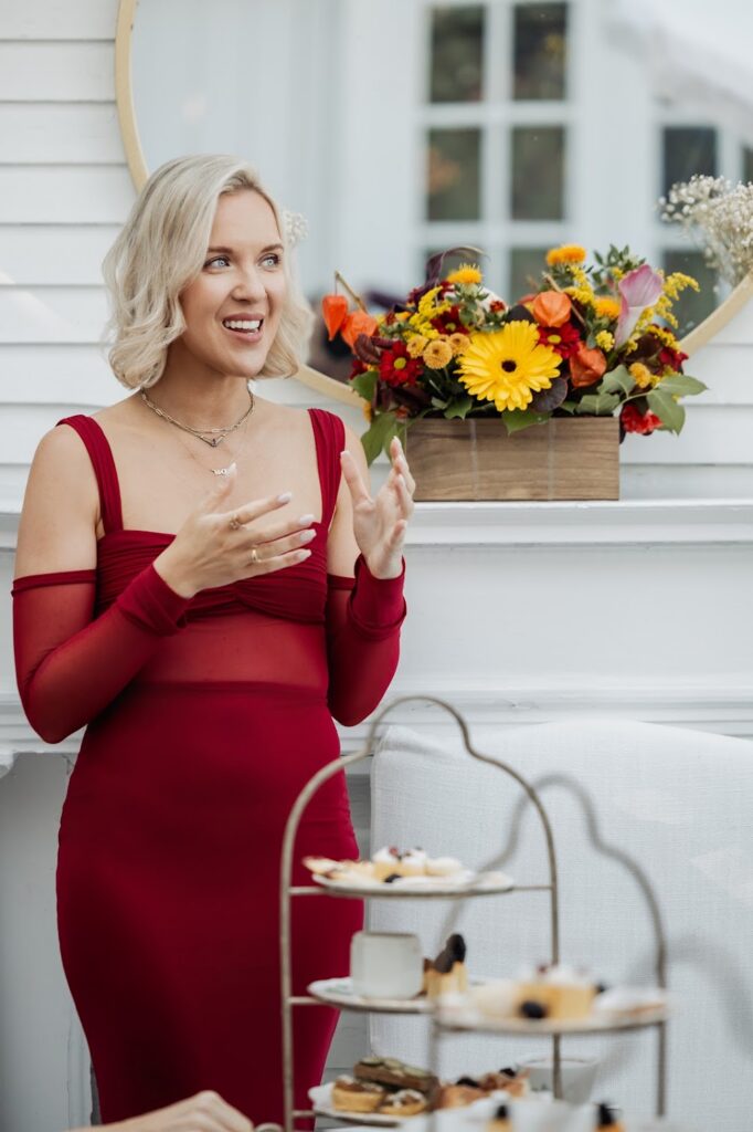 personal branding consultant Katrina Owens stands in a red dress at an event speaking to a group of entrepreneurs