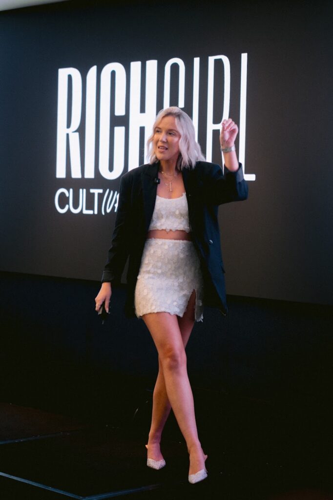 Author Katrina Owens stands on stage at an event to teach about the power of personal branding and how to do it well