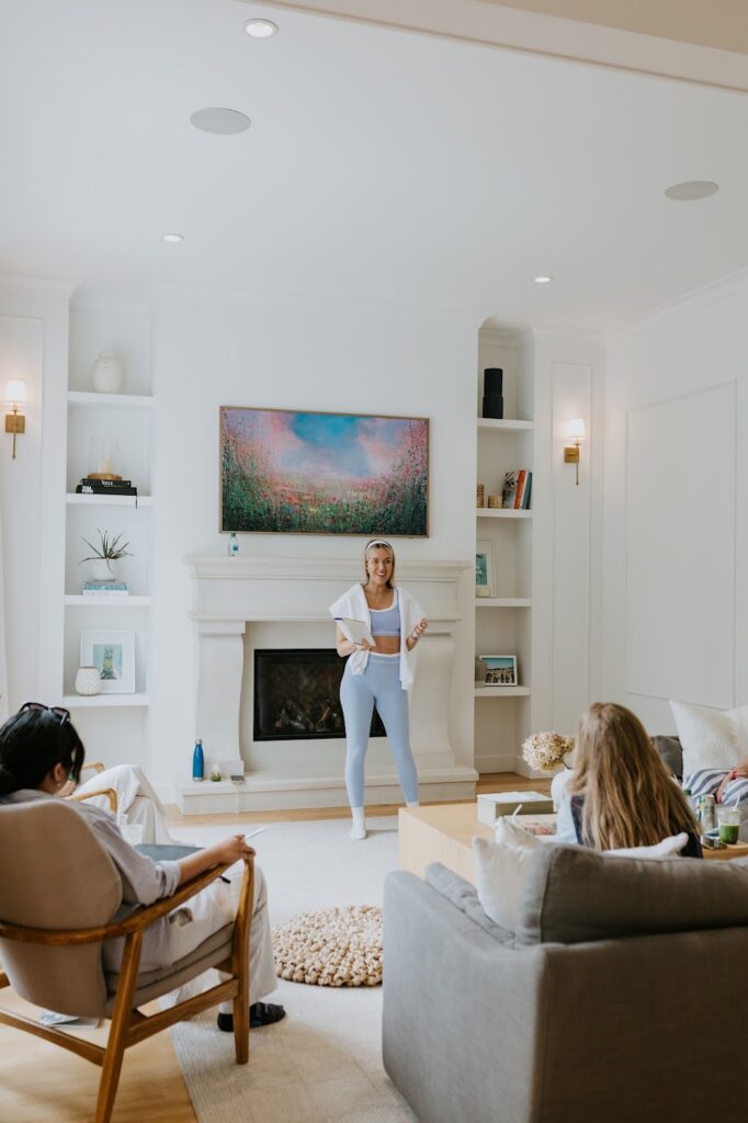 Katrina Owens, a coach who offers Personal Branding Packages, stands in the centre of a modern neutral living room educating entrepreneurs