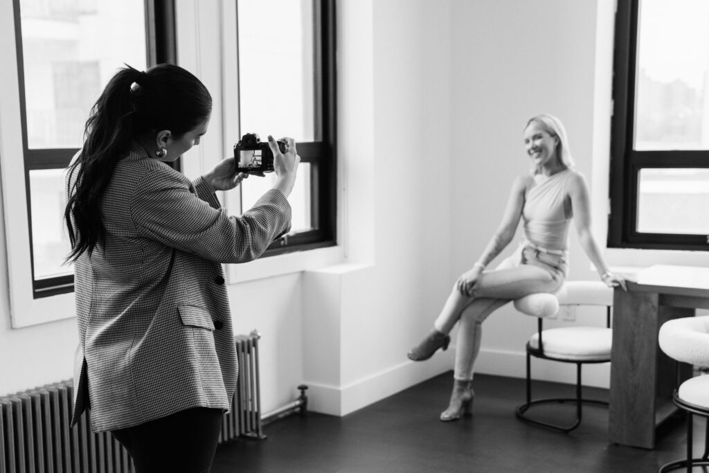 podcaster Katrina Owens who teaches how to start a podcast and make money to her clients sits for brand photos in this black and white photo