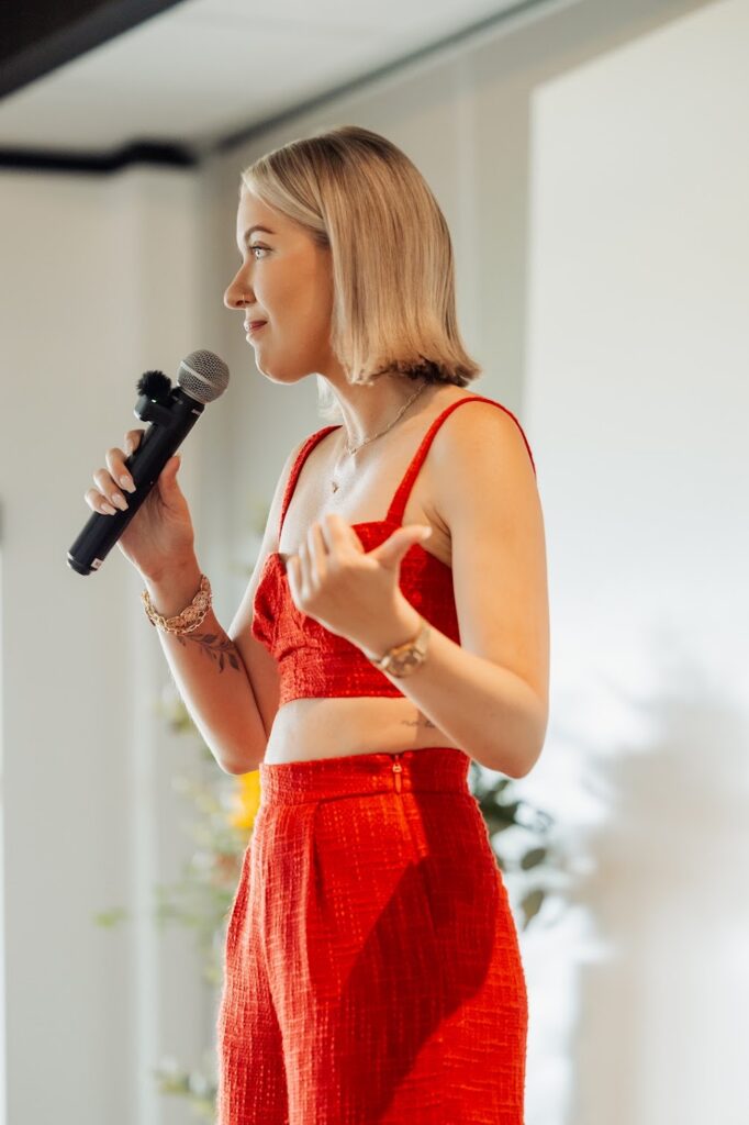 Katrina Owens, who speaks to students and inspires them from the stage, stands with a microphone in front of a crowd